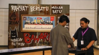 Pengunjung melihat karya seni dalam Pameran Jakarta Provoke 2025 di Gedung Pos Bloc, Jakarta, Kamis (19/6/2025). [Suara.com/Alfian Winanto]
