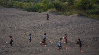 Warga bermain bola di kawasan Gumuk Pasir, Bantul, DI Yogyakarta, Kamis (19/6/2025). [ANTARA FOTO/Hendra Nurdiyansyah/nym]