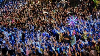 Warga menyaksikan berbagai penampilan pada acara malam puncak HUT ke-498 Jakarta di Lapangan Banteng, Jakarta, Minggu (22/6/2025). [ANTARA FOTO/Muhammad Adimaja/bar]