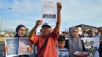 Keluarga Afif Maulana, pelajar SMP yang tewas diduga akibat penyiksaan oleh polisi tahun lalu, membawa poster di Tempat Kejadian Perkara saat aksi memperingati Hari Anti Penyiksaan sedunia di Jembatan Kuranji, Padang, Sumatera Barat, Selasa (24/6/2025). [ANTARA FOTO/Iggoy el Fitra/bar]
