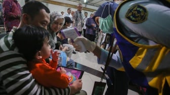 Petugas kesehatan dari Karantina Kesehatan Bandara memeriksa suhu badan sejumlah Warga Negara Indonesia (WNI) setibanya dari Iran di Terminal 3 Bandara Soekarno Hatta, Selasa (24/6/2025). [ANTARA FOTO/Muhammad Iqbal/bar]