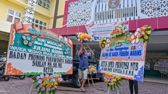 Pekerja menurunkan karangan bunga ucapan belasungkawa untuk pendaki Gunung Rinjani berwarganegaraan Brazil Juliana Marins di Rumah Sakit Bhayangkara Polda NTB di Mataram, NTB, Kamis (26/6/2025). [ANTARA FOTO/Ahmad Subaidi/rwa]