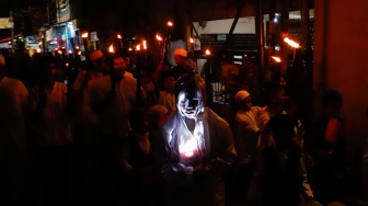 Sejumlah warga mengikuti pawai obor di RW 08 Kelurahan Menteng, Jakarta, Kamis (26/6/2025). [Suara.com/Alfian Winanto]
