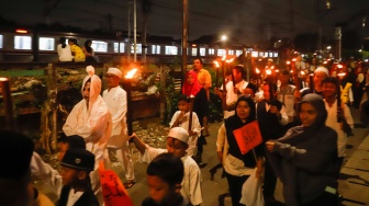Sejumlah warga mengikuti pawai obor di RW 08 Kelurahan Menteng, Jakarta, Kamis (26/6/2025). [Suara.com/Alfian Winanto]