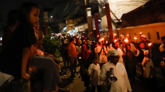 Sejumlah warga mengikuti pawai obor di RW 08 Kelurahan Menteng, Jakarta, Kamis (26/6/2025). [Suara.com/Alfian Winanto]