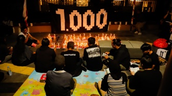 Peserta aksi berdoa saat peringatan 1.000 hari Tragedi Kanjuruhan di depan Museum Polri, Jakarta, Jumat (27/6/2025). [Suara.com/Alfian Winanto]