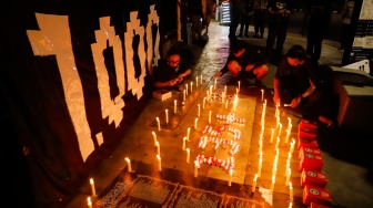 Peserta aksi membakar lilin saat peringatan 1.000 hari Tragedi Kanjuruhan di depan Museum Polri, Jakarta, Jumat (27/6/2025). [Suara.com/Alfian Winanto]