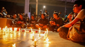 Peserta aksi berdoa saat peringatan 1.000 hari Tragedi Kanjuruhan di depan Museum Polri, Jakarta, Jumat (27/6/2025). [Suara.com/Alfian Winanto]