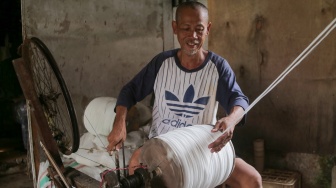 Pekerja memintal benang di sebuah industri kawasan Cipulir, Jakarta, Senin (30/6/2025). [Suara.com/Alfian Winanto]