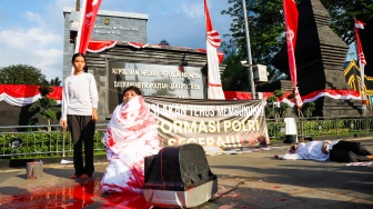 Massa dari Koalisi Masyarakat Sipil untuk Reformasi Kepolisian (Koalisi RFP) menggelar aksi teaterikal di depan Polda Metro Jaya, Jakarta, Selasa (1/7/2025). [Suara.com/Alfian Winanto]