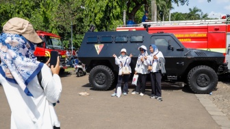 Warga menghadiri HUT ke-79 Bhayangkara di kawasan Monumen Nasional (Monas), Jakarta, Selasa (1/7/2025).  [Suara.com/Alfian Winanto]