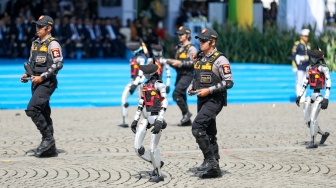 Sejumlah personel robot humanoid mengikuti parade upacara HUT ke-79 Bhayangkara di kawasan Monumen Nasional (Monas), Jakarta, Selasa (1/7/2025).  [Suara.com/Alfian Winanto]