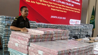 Petugas merapikan barang bukti uang sitaan saat konferensi pers terkait tindak pidana korupsi pemberian fasilitas crude palm oil (CPO) dan turunannya di Gedung Bundar Jampidus Kejaksaaan Agung, Jakarta, Rabu (2/7/2025). [ANTARA FOTO/Muhammad Adimaja/tom]