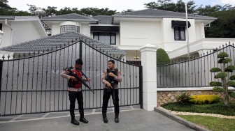 Polisi berjaga di gerbang rumah saat penyidik KPK melakukan penggeledahan terkait kasus dugaan korupsi proyek pembangunan jalan, di rumah pribadi Kepala Dinas PUPR Provinsi Sumatera Utara Topan Obaja Putra Ginting di kompleks Royal Sumatera, Medan, Sumatera Utara, Rabu (2/7/2025). [ANTARA FOTO/Yudi Manar/tom]