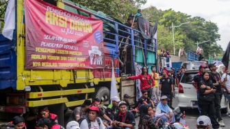 Para sopir truk saat menggelar aksi soal nol kelebihan muatan atau zero over dimensi over loading (ODOL) di Jalan Medan Merdeka Selatan, Jakarta, Rabu (2/7/2025). [Suara.com/Alfian Winanto]