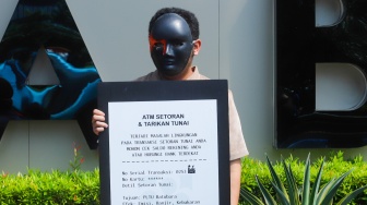 Sejumlah aktivis dari Enter Nusantara melakukan aksi teatrikal di depan Graha BNI, Jakarta, Jumat (4/7/2025). [Suara.com/Alfian Winanto]