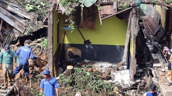 Petugas membersihkan material tanah longsor yang menimpa rumah di Megamendung, Puncak, Kabupaten Bogor, Jawa Barat, Senin (7/7/2025). [ANTARA FOTO/Yulius Satria Wijaya/nym]