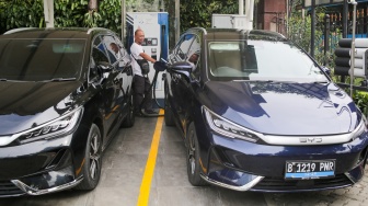 Pemilik kendaraan melakukan pengisian daya kendaraan listrik di SKPLU, Jakarta, Senin (7/7/2025). [Suara.com/Alfian Winanto]