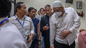 Ayah almarhum korban penembakan pelajar oleh polisi GRO (17) Andi Prabowo (kedua kiri) menyaksikan terdakwa yang diduga penembak seorang anak Robig Zaenudin (kanan) jalan memasuki ruang sidang sebelum sidang pembacaan tuntutan di Pengadilan Negeri Semarang, Jawa Tengah, Selasa (8/7/2025). [ANTARA FOTO/Aji Styawan/agr]