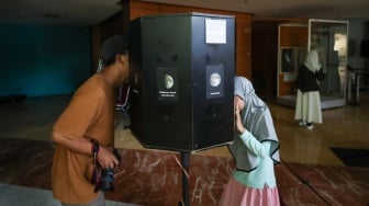 Pengunjung menyaksikan simulasi langit dan penjelasan mengenai astronomi di planetarium mini, kawasan Taman Ismail Marzuki, Jakarta, Selasa (8/7/2025). [Suara.com/Alfian Winanto]