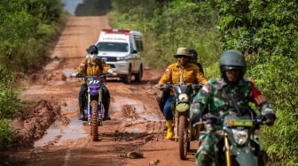 Petugas kesehatan menggunakan sepeda motor dikawal petugas keamanan melintasi jalan rusak saat layanan jemput bola Program Cek Kesehatan Gratis di Kecamatan Elikobel, Kampung Bonggai, Kabupaten Merauke, Papua Selatan, Selasa (8/7/2025). [ANTARA FOTO/Bayu Pratama S/foc]