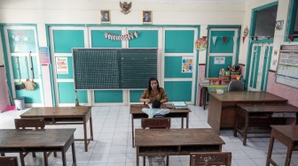 Guru mengajar seorang siswa kelas satu saat kegiatan Masa Pengenalan Lingkungan Sekolah Pendidikan (MPLS) di SD Negeri Kauman 27 Solo, Jawa Tengah, Senin (14/7/2025). [ANTARA FOTO/Mohammad Ayudha/rwa]