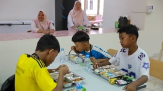 Siswa Makan Bergizi Gratis (MBG) pada pembukaan masa pengenalan lingkungan sekolah (MPLS) di Sekolah Rakyat Menengah Pertama (SRMP) Sentra Handayani, Jakarta, Senin (14/7/2025). [Suara.com/Alfian Winanto]