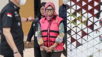 Tersangka Direktur Sekolah Dasar Direktorat Jenderal Pendidikan Anak Usia Dini, Pendidikan Dasar dan Pendidikan Menengah tahun 2020-2021, Sri Wahyuningsih dibawa ke mobil tahanan di Kejaksaan Agung, Jakarta, Selasa (15/7/2025). [Suara.com/Alfian Winanto]