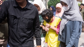 Seorang tersangka (tengah) digiring untuk dihadirkan saat rilis pengungkapan kasus perdagangan manusia dengan korban bayi di Mapolda Jawa Barat, Bandung, Jawa Barat, Kamis (17/7/2025). [ANTARA FOTO/Novrian Arbi/tom]