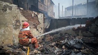 Petugas pemadam kebakaran melakukan pendinginan di lokasi kebakaran permukiman penduduk di Duri Utara, Tambora, Jakarta, Senin (21/7/2025). [ANTARA FOTO/Fauzan/bar