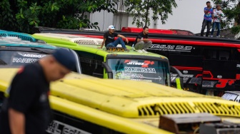 Massa yang tergabung dalam Solidaritas Pekerja Pariwisata Jawa Barat berdiri di atas bus saat aksi unjuk rasa di depan Gedung Sate, Bandung, Jawa Barat, Senin (21/7/2025). [ANTARA FOTO/Novrian Arbi/bar]