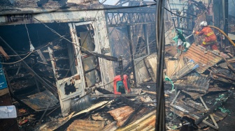 Petugas pemadam kebakaran melakukan pendinginan di lokasi kebakaran permukiman penduduk di Duri Utara, Tambora, Jakarta, Senin (21/7/2025). [ANTARA FOTO/Fauzan/bar]