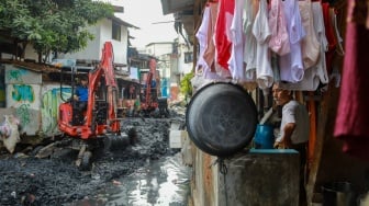 Petugas dari Suku Dinas Sumber Daya Air (SDA) Jakarta Pusat melakukan pengerukan lumpur di aliran anak Kali Krukut, Kebon Melati, Tanah Abang, Jakarta, Selasa (22/7/2025). [Suara.com/Alfian Winanto]