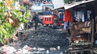 Petugas dari Suku Dinas Sumber Daya Air (SDA) Jakarta Pusat melakukan pengerukan lumpur di aliran anak Kali Krukut, Kebon Melati, Tanah Abang, Jakarta, Selasa (22/7/2025). [Suara.com/Alfian Winanto]