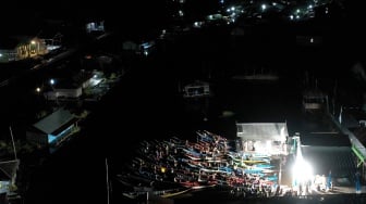 Foto udara sejumlah warga menonton bioskop terapung dari perahunya di Desa Muara Enggelam, Muara Wis, Kutai Kartanegara, Kalimantan Timur, Selasa (22/7/2025). [ANTARA FOTO/M Risyal Hidayat/tom] 
