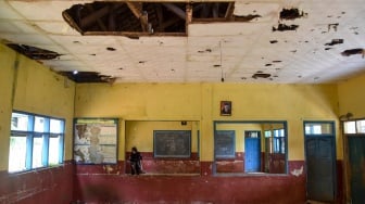 Seorang guru membersihkan ruang kelas yang rusak di SD Negeri Mandalawangi, Desa Lengkongbarang, Kecamatan Cikatomas, Kabupaten Tasikmalaya, Jawa Barat, Kamis (24/7/2025). [ANTARA FOTO/Adeng Bustomi/foc]