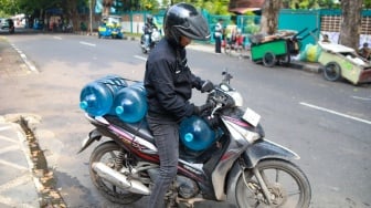 Warga mengisi air minum gratis di kawasan Rawamangun, Jakarta, Kamis (24/7/2025). [Suara.com/Alfian Winanto]
