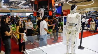Pengunjung melihat Robot Humanoid di ajang pameran automotif Gaikindo Indonesia International Auto Show (GIIAS) 2025 di Indonesia Convention Exhibition (ICE) BSD, Tangerang, Banten, Sabtu (26/7/2025). [Suara.com/Alfian Winanto]
