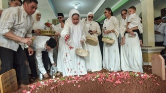 Istri Menteri Agama periode 2009-2014 Suryadharma Ali, Wardhatul Asriah (tengah) bersama keluarga menaburkan bunga dan berdoa di pemakaman area Pondok Pesantren Miftahul Ulum, Cikarang Barat, Kabupaten Bekasi, Jawa Barat, Kamis (31/7/2025).[ANTARA FOTO/ Fakhri Hermansyah/rwa]