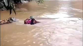 Viral Bidan Dona Berenang Seberangi Sungai Demi Obati Warga di Pasaman, Jembatan Putus!
