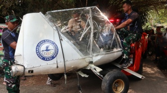 Prajurit TNI AU mengevakuasi bangkai pesawat latih sipil Microlight Fixedwing Quicksilver GT500 dengan register PK-S126 yang jatuh di perkebunan warga, TPU Astana, Ciampea, Kabupaten Bogor, Jawa Barat, Minggu (3/8/2025). [ANTARA FOTO/Fadli/Arf/rwa]