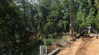 Petugas menggunakan alat berat saat memasang rangka besi pondasi untuk perbaikan jalan nasioal Gunung Gumitir, Jember, Jawa Timur, Minggu (3/8/2025). [ANTARA FOTO/Seno/rwa]