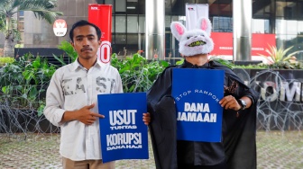 Pegiat antikorupsi dari Indonesia Corruption Watch (ICW) menggelar aksi seusai melaporkan kasus dugaan korupsi penyelenggaraan haji 1446H/2025 di Gedung Merah Putih KPK, Jakarta, Selasa (5/8/2025). [Suara.com/Alfian Winanto]