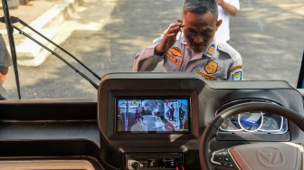 Petugas memperhatikan purwarupa angkot listrik pintar saat diperkenalkan di Kantor Dinas Perhubungan Kota Bandung, Gedebage, Bandung, Jawa Barat, Senin (4/8/2025). [ANTARA FOTO/Raisan Al Farisi/nym]