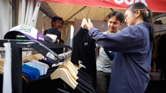 Pembeli memillih busana yang dijual dalam pameran JakCloth Summerfest 2025 di Blok M Hub, Jakarta, Sabtu (9/8/2025). [Suara.com/Alfian Winanto]