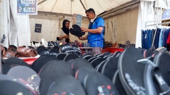 Pembeli memillih sandal yang dijual dalam pameran JakCloth Summerfest 2025 di Blok M Hub, Jakarta, Sabtu (9/8/2025). [Suara.com/Alfian Winanto]
