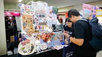 Pengunjung membeli aksesoris dalam pameran Indonesia Game Week 2025 di Blok M Hub, Jakarta, Sabtu (9/8/2025). [Suara.com/Alfian Winanto]