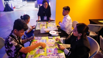 Pengunjung bermain Trading Card Game (TCG) dalam pameran Indonesia Game Week 2025 di Blok M Hub, Jakarta, Sabtu (9/8/2025). [Suara.com/Alfian Winanto]