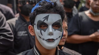 Seorang warga memakai topeng saat mengikuti unjuk rasa di depan Kantor Bupati Pati, Kabupaten Pati, Jawa Tengah, Rabu (13/8/2025). [ANTARA FOTO/Aji Styawan/tom]