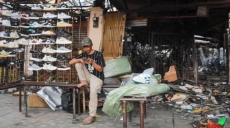 Pedagang menjajakan dagangannya pada lokasi bekas kebakaran di Pasar Taman Puring, Jakarta, Rabu (13/8/2025). [Suara.com/Alfian Winanto]
